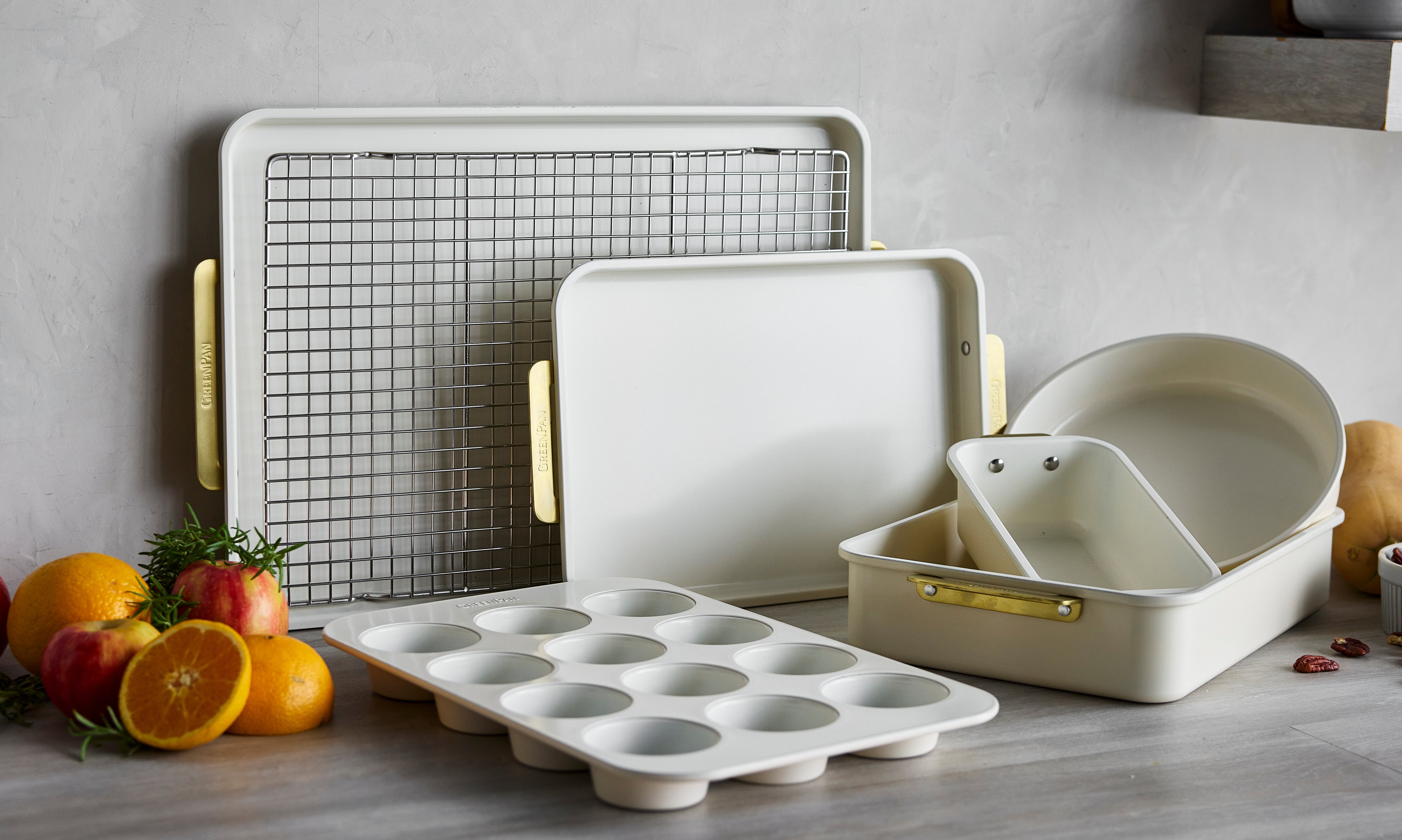 Cream bakeware pieces arranged with fruit and baking ingredients